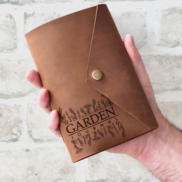 Leather personalised gardeners journal, snap style held in hand